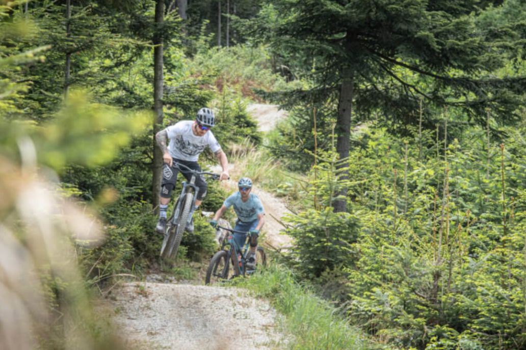 2 mountainbikers over de flow line in Bikepark Trail Land